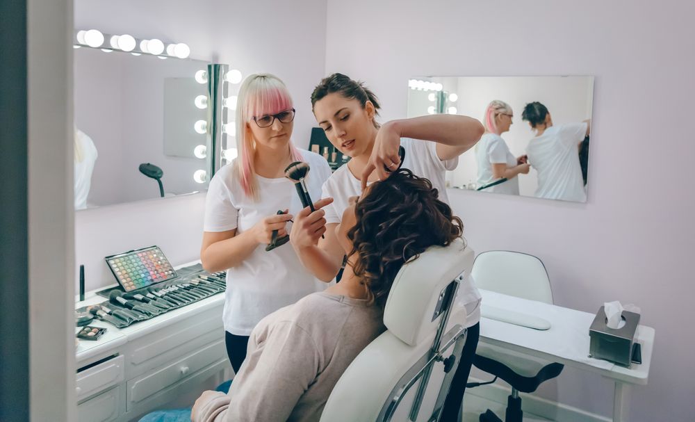 Portrait of make-up artist working with a female client in a beauty center