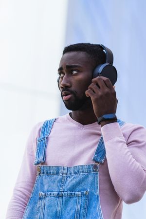 Stylish Black man listening to music in headphones