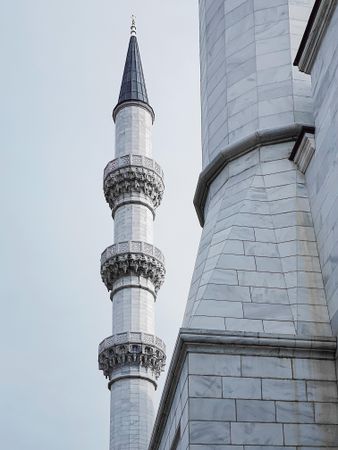 Minaret of mosque in cloudy grey sky