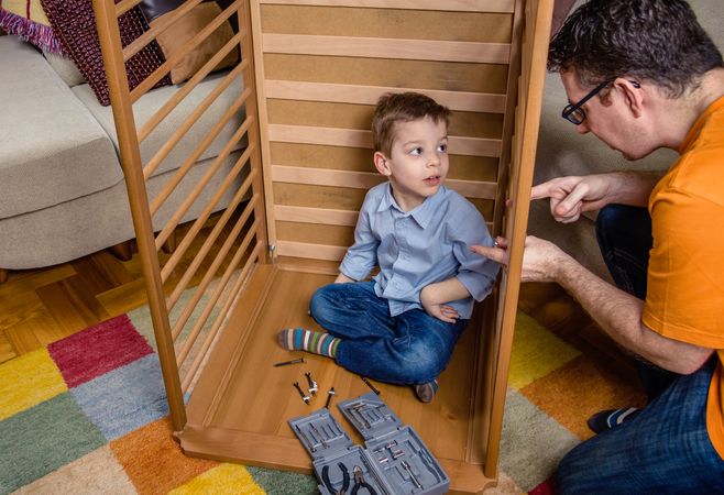 Father and son assembling cot for a newborn at home