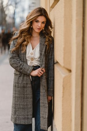Woman leaning on wall on street