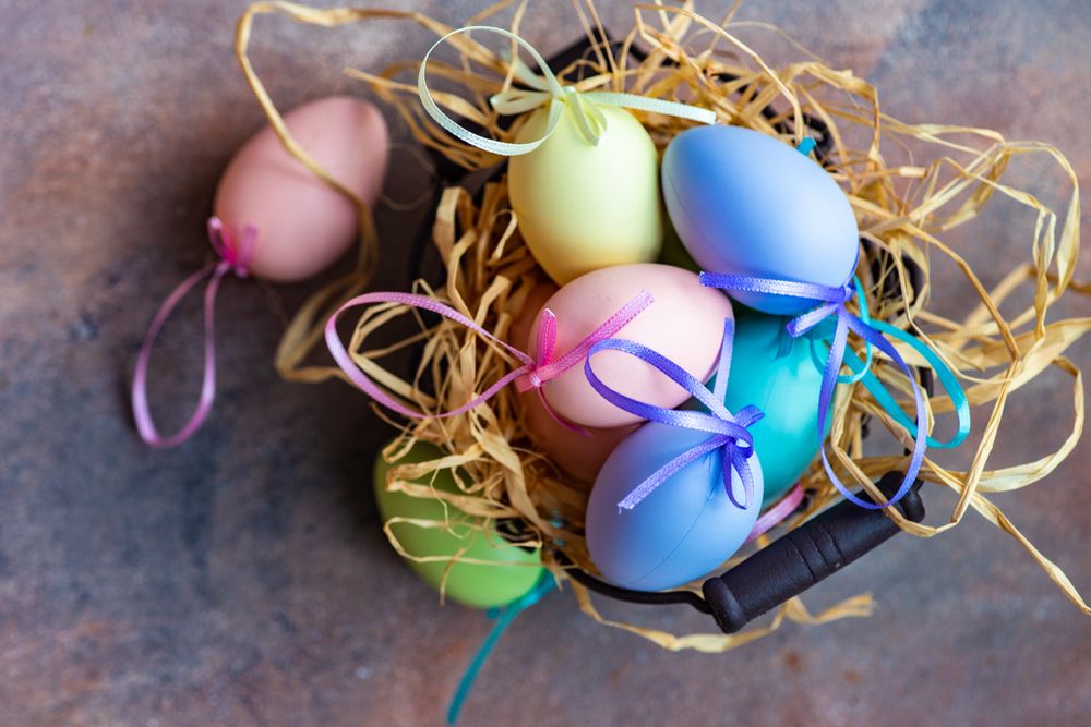 Decorative Easter eggs in straw on table