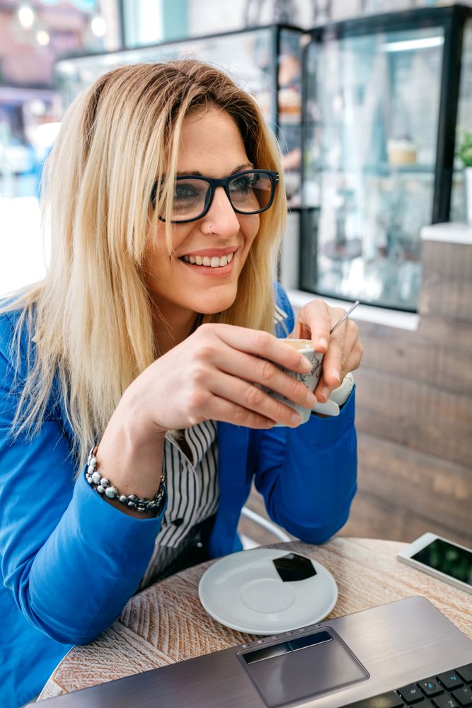 Woman drinking coffee and using the laptop