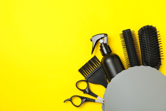 Composition with hairdresser accessories on yellow background, space for text