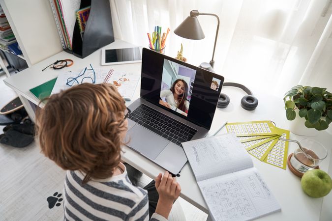 Boy doing homework with classmate during video call