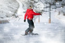 Unrecognizable snowboarder riding on slope