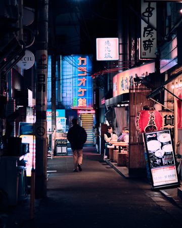 Man walking down the alley during nighttime