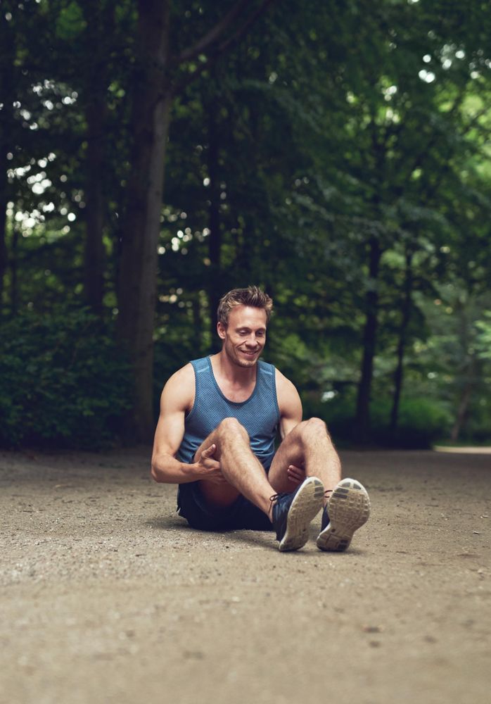 Athletic man stretching in park before a jog