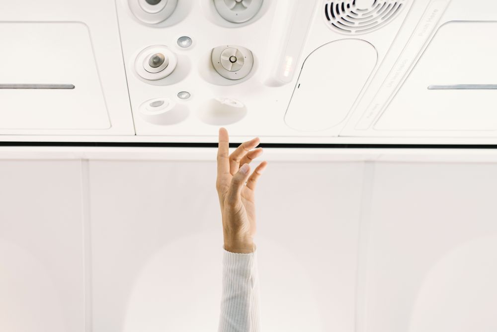 Person pressing button on panel up airplane