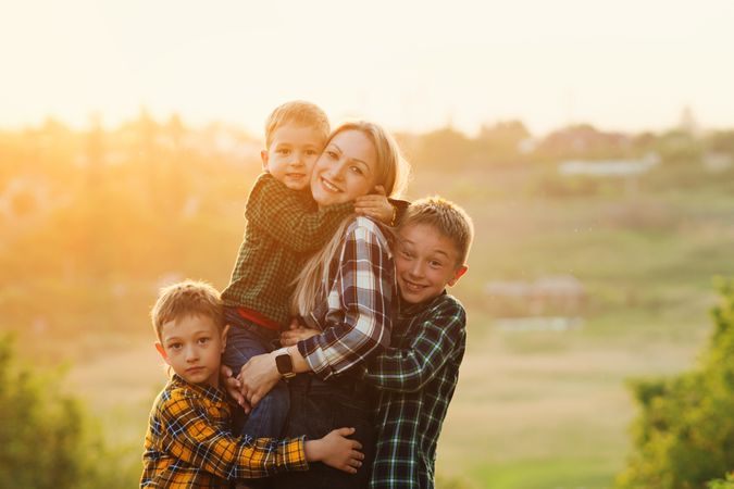Happy mother and sons at dusk together in field
