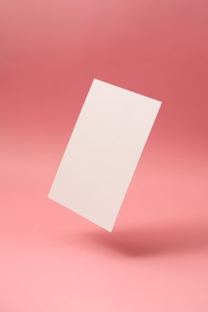 Paper card note on bright pastel pink sunlit background
