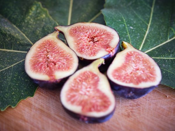 Halved figs near green leaves