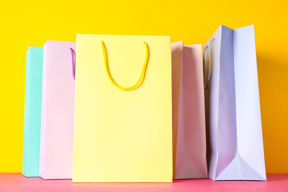 Color paper bags on multicolor background, space for text