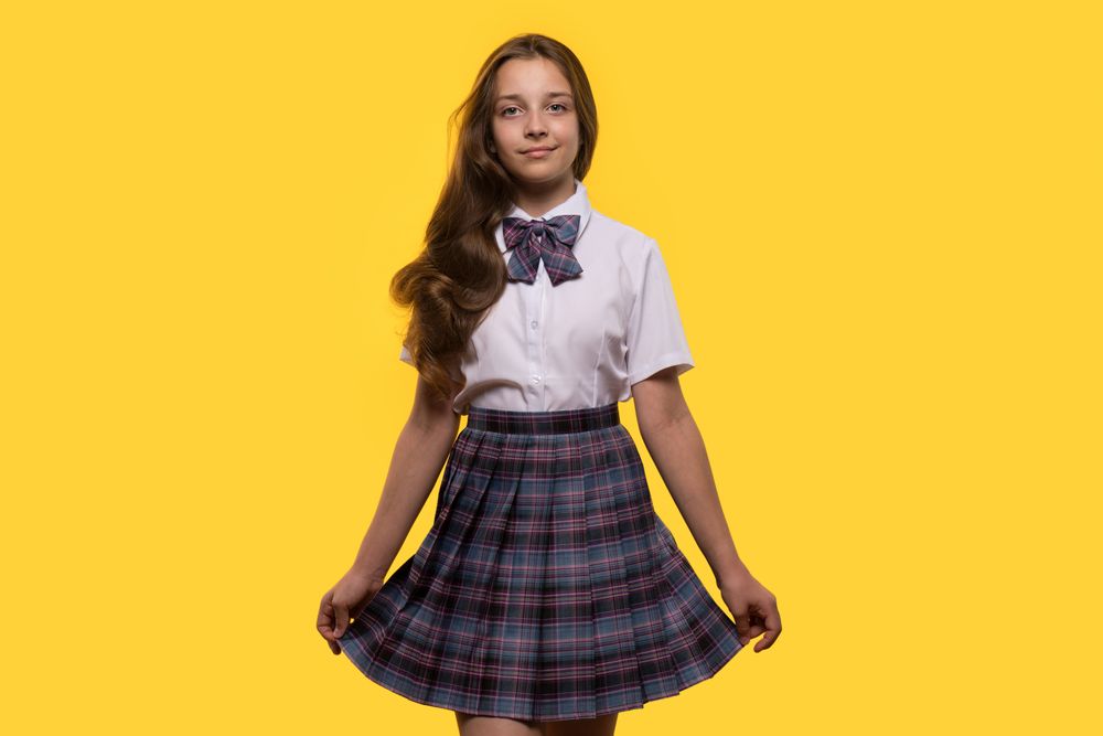 Schoolgirl poses gracefully in plaid skirt