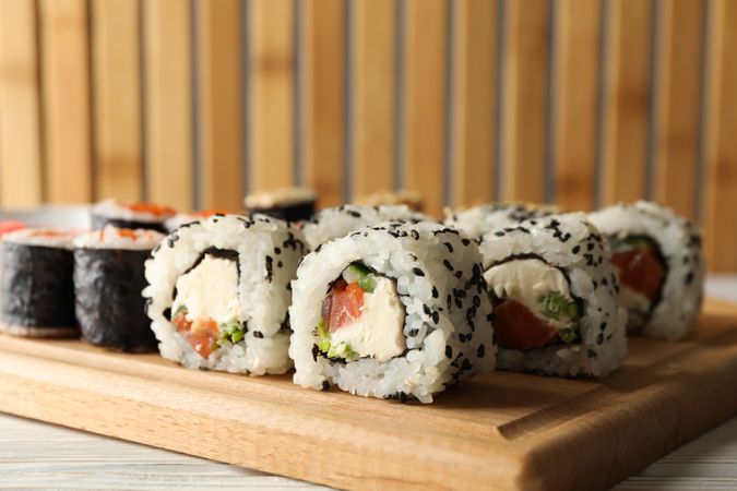 Delicious sushi rolls on wooden background, close up. Japanese food