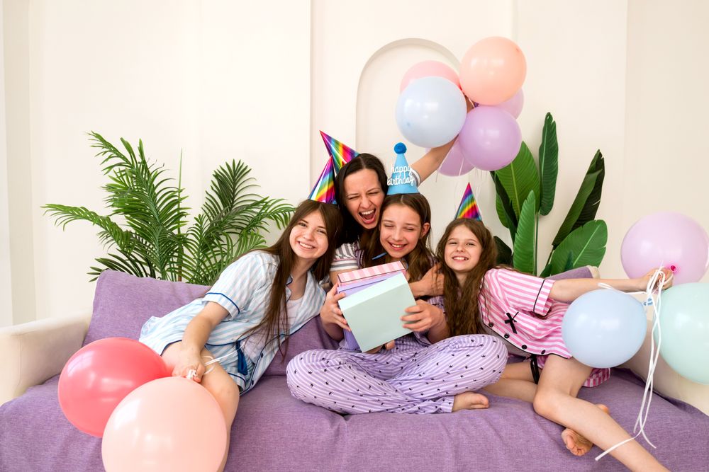 Family laughing and hugging during joyful birthday party at home.