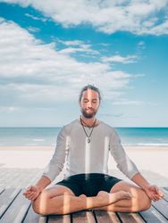 Man meditating on beach
