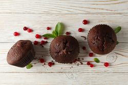 Composition with chocolate muffins and berries on wooden background