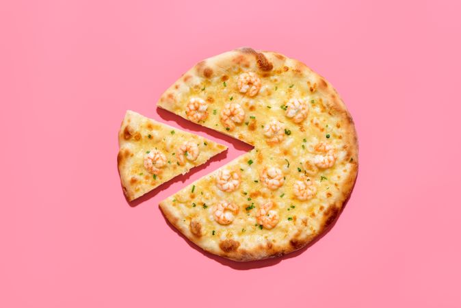 Homemade shrimp pizza isolated on a pink background