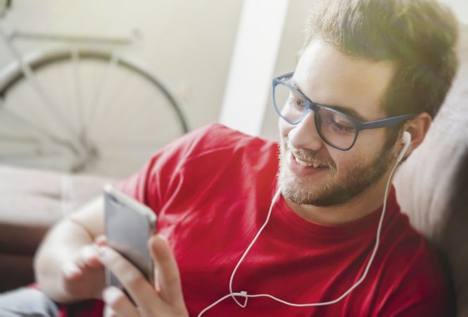 Happy man listening to music on couch