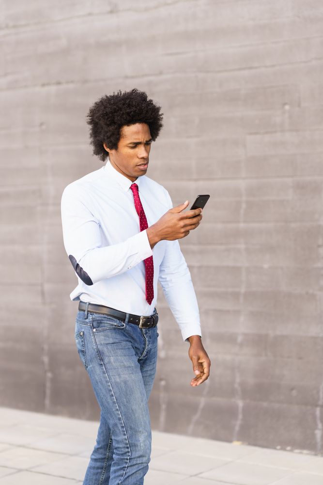 Serious man outside looking at his phone