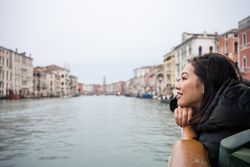 Asian female on vacation on ferryboat on waterline at city