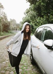 Woman stretching near car in park