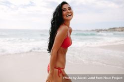 Smiling woman in bikini walking on the sea shore 5nWv64