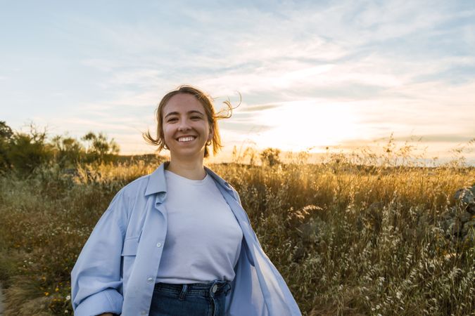 blonde woman portrait on a field during sunset