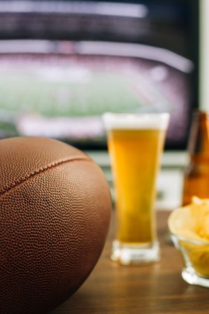 Beer and snacks prepared for watching american football on TV