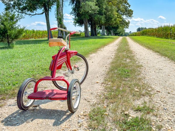 Red tricycle on farm road