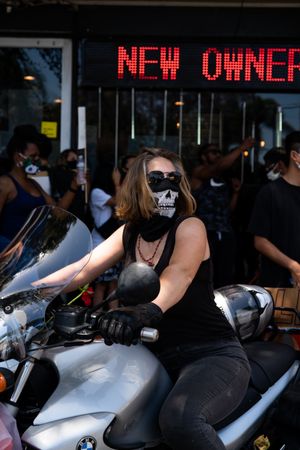 Los Angeles, CA, USA — June 14th, 2020: woman on motorcycle with skull PPE mask at protest