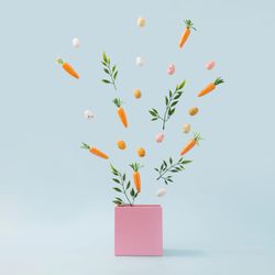 Spring leaves, Easter eggs and carrots coming out of pink box
