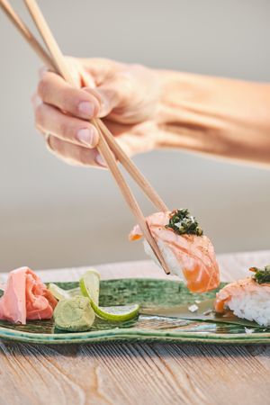 Unrecognizable person eating sake nigiri sushi