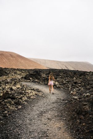 Back of female in shorts walking through volcanic terrain in Lanzarote