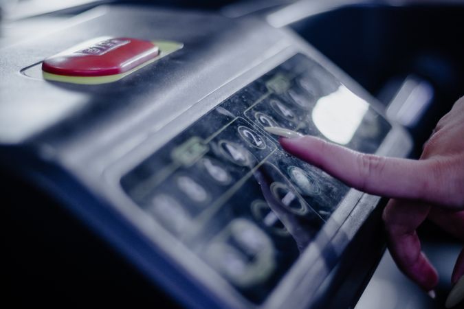 Woman pressing the 2 button on the treadmill panel, detail shot
