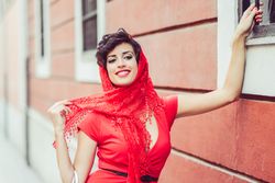 Elegant woman with lace scarf holding onto into railing