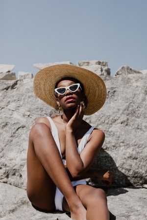 Woman in swimsuit wearing sunglasses and sun hat
