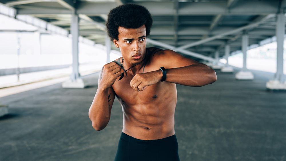 Athletic Black male practicing boxing during training