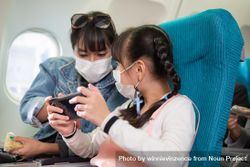 Woman and child checking phone together in airplane bGYvv5