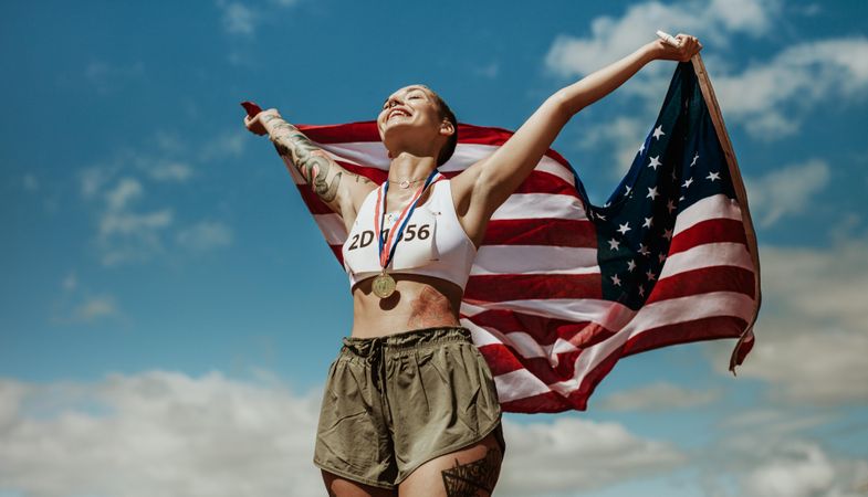 Athlete enjoying victory with US national flag against sky