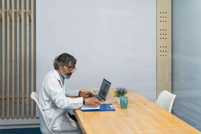 Mature doctor talking to patient on video chat
