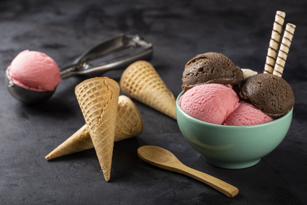 Bowl with Neapolitan ice cream on dark background.