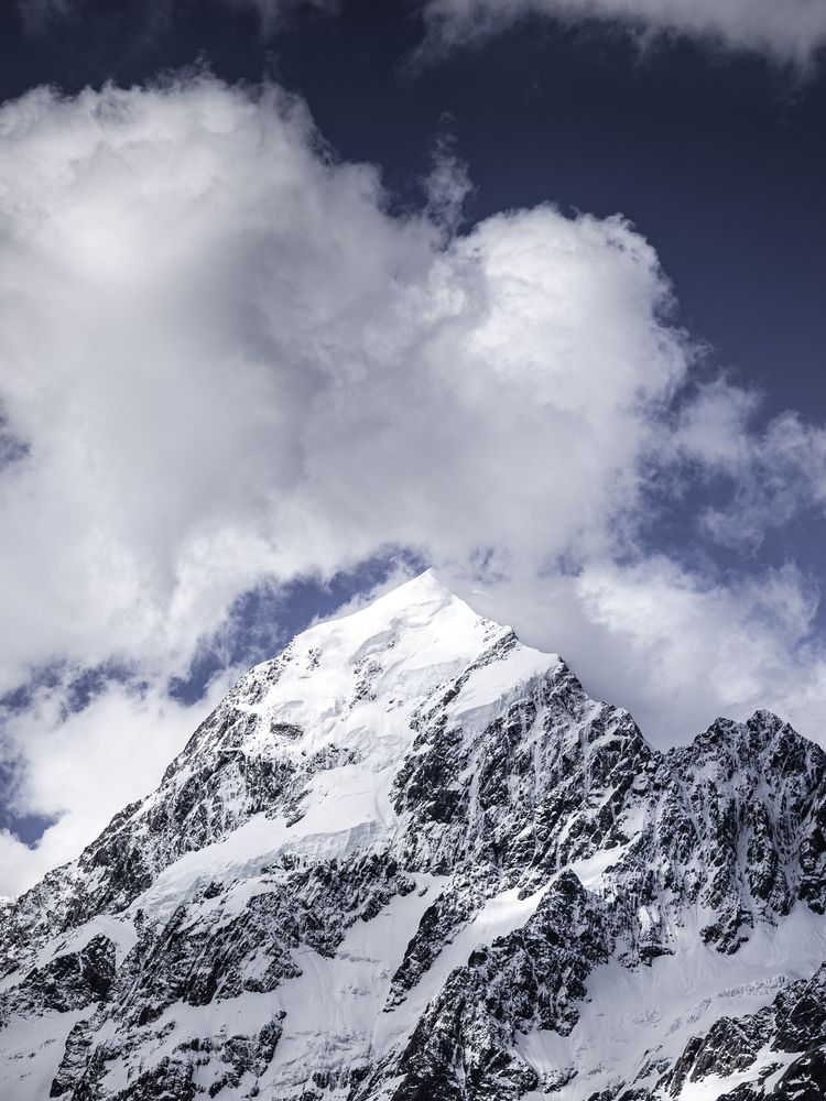 Beautiful view of snow capped mountain summit with clouds above