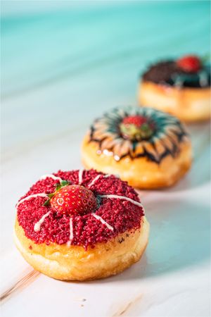 Mini donuts with chocolate and strawberry toppings, captured in a low angle macro shot