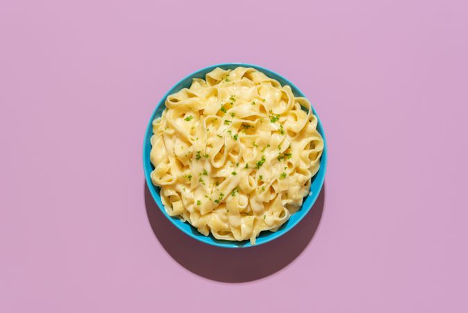 Pasta fettuccine alfredo above view on a purple background