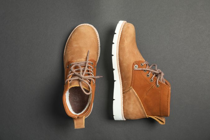 Winter boots on dark background, top view