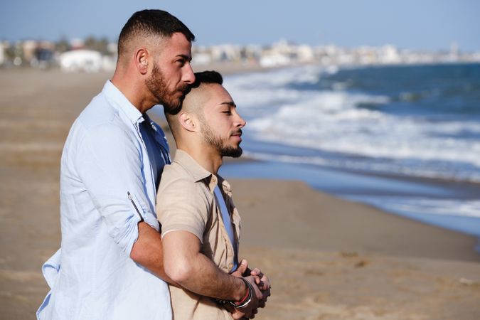 Male couple hugging on seaside