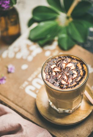 Top view of latte with decorative pattern in chocolate syrup on coffee bag