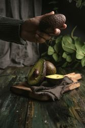 Person hands holding avocados